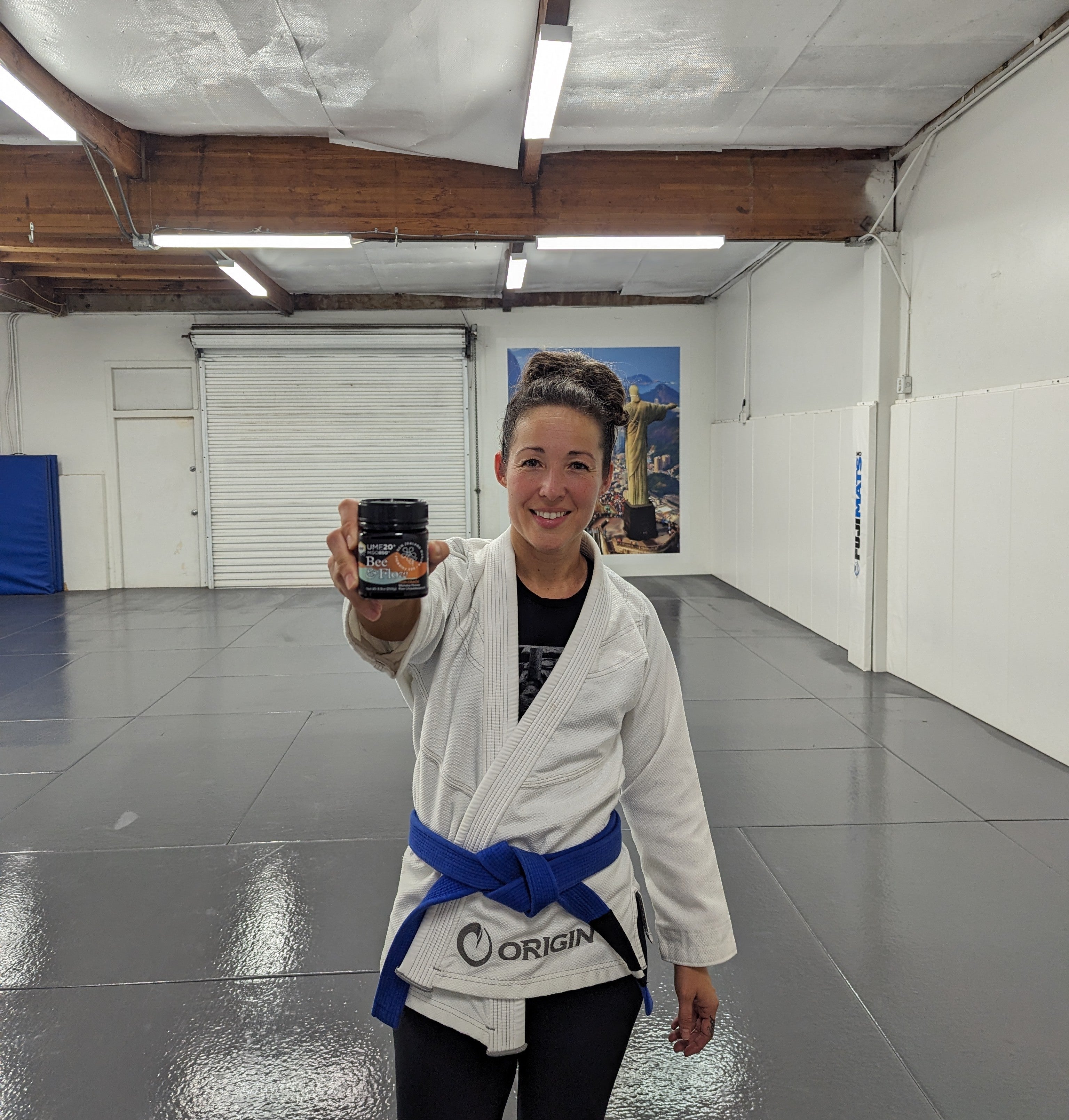 Blue belt female jiu jitsu athlete with UMF20 jar